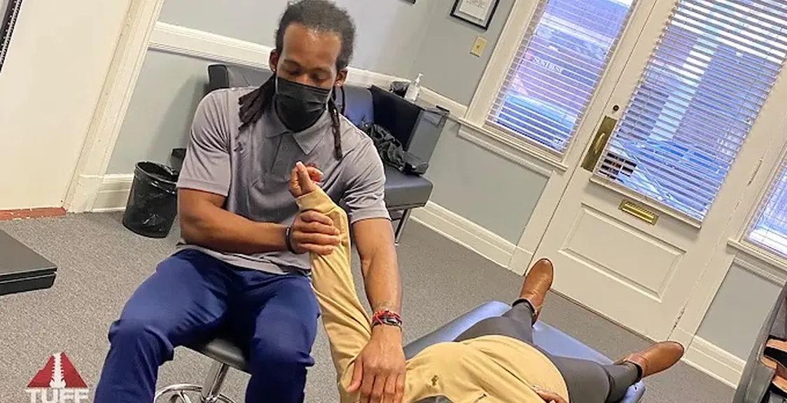 Dr. Lewis stretching a patient's shoulder and arm